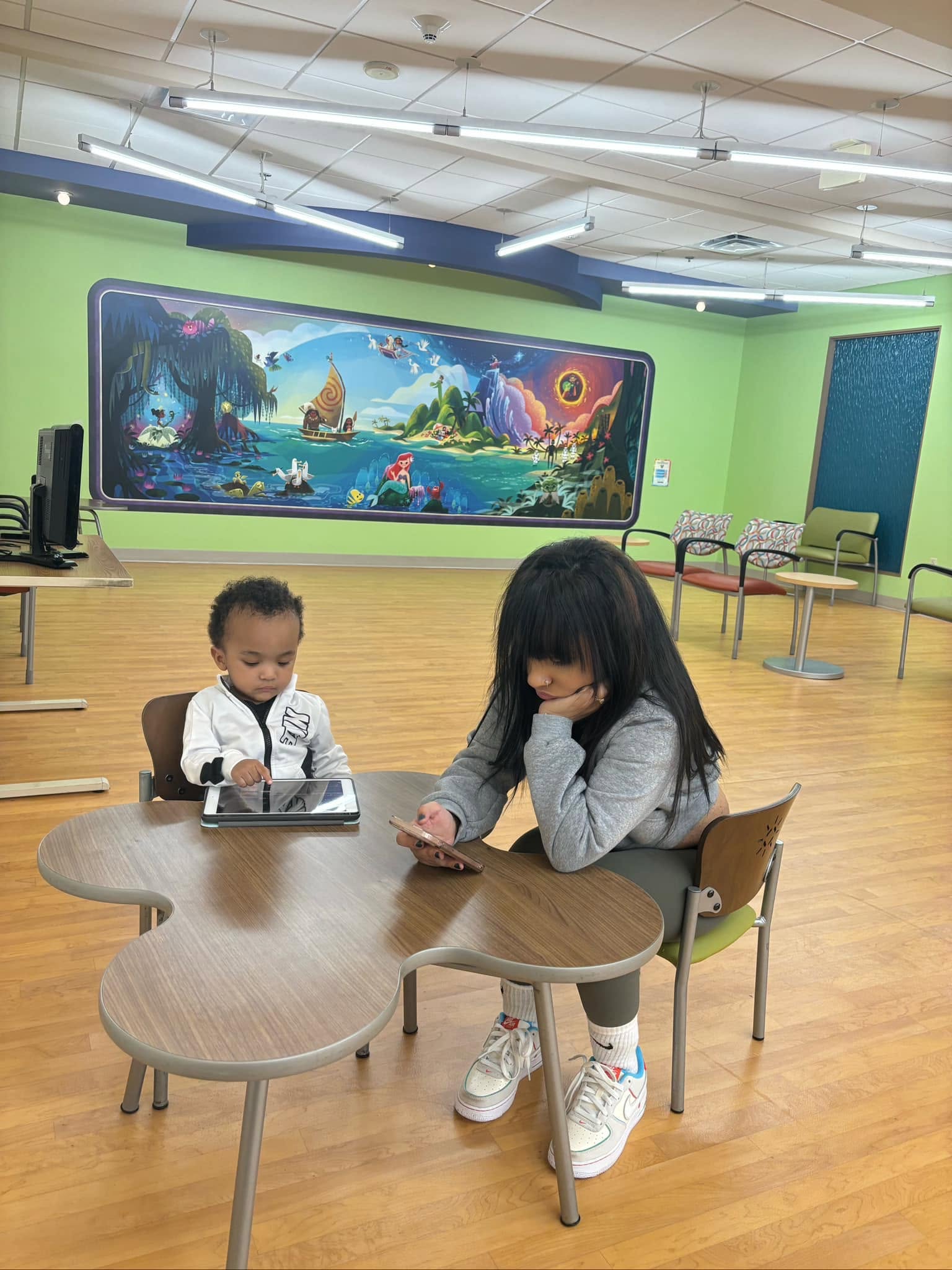 Her and her son at a colorful mural